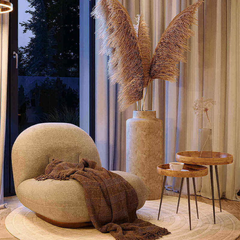 Eleganter Raum mit kurvigen Möbeln, Pflanzen und warmem Licht für eine gemütliche Atmosphäre.