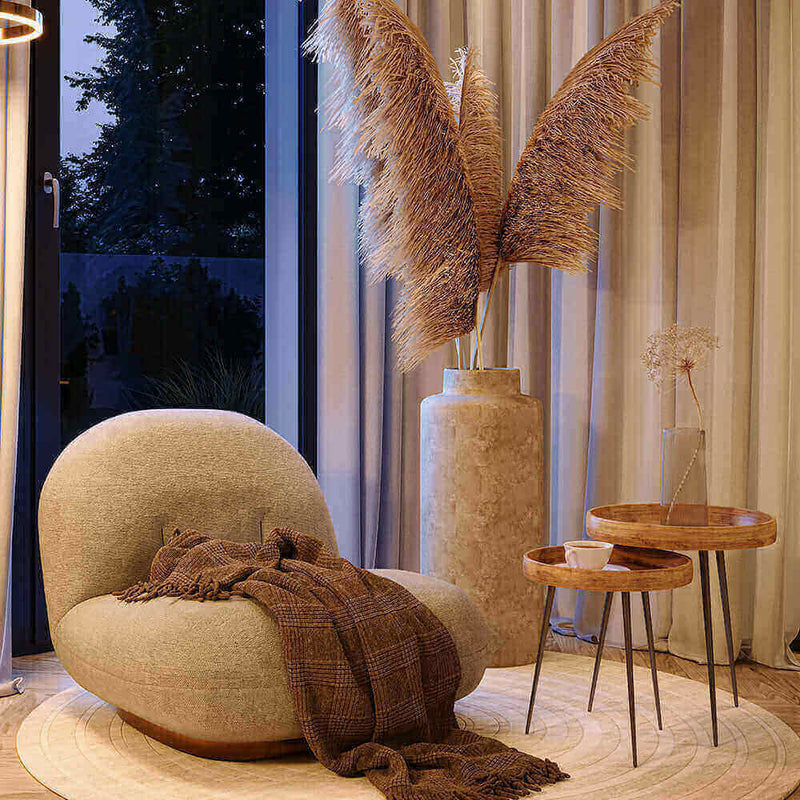 Eleganter Raum mit kurvigen Möbeln, Pflanzen und warmem Licht für eine gemütliche Atmosphäre.