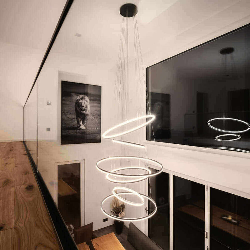 Modernes Lichtdesign mit schwebenden Ringen, beleuchtet einen eleganten Raum mit Kunstwerk eines Löwen.