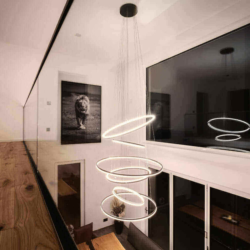 Modernes Lichtdesign mit schwebenden Ringen, beleuchtet einen eleganten Raum mit Kunstwerk eines Löwen.