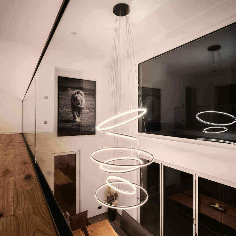Modernes Lichtdesign mit schwebenden Ringen, beleuchtet einen eleganten Raum mit Kunstwerk eines Löwen.