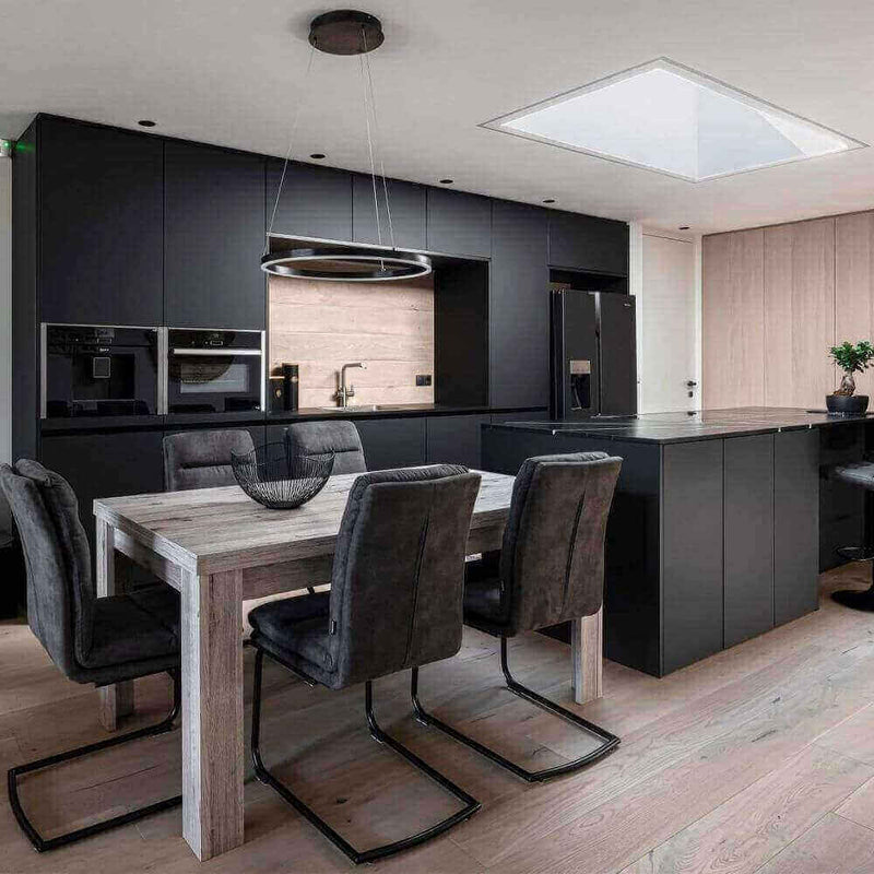 Moderne Küche mit schwarzem Design und Holzdetails, Tisch und Stühlen in stilvollem Ambiente.