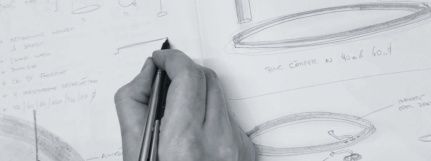 Hand skizziert Designideen auf einem Notizblock, technische Zeichnungen und Notizen sichtbar.