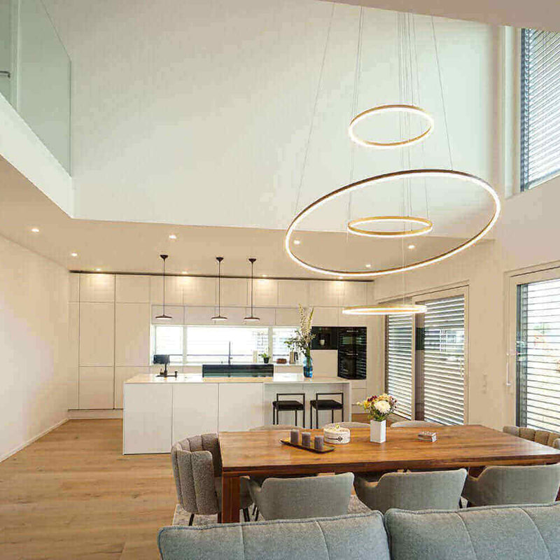 Elegantes Wohnzimmer mit modernen Leuchten und offener Küche im skandinavischen Stil.