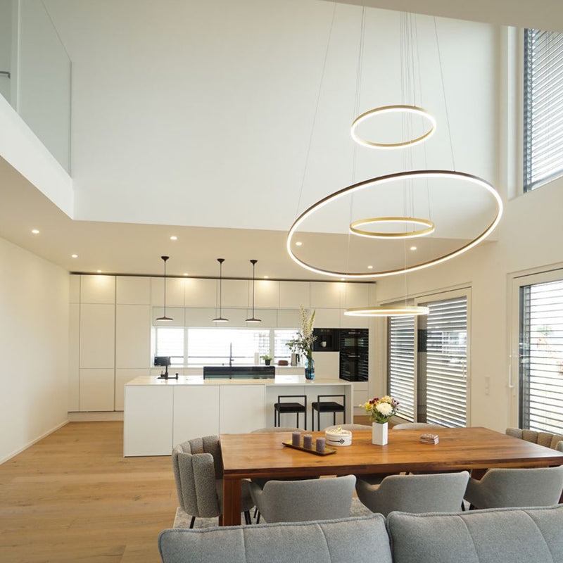 Elegantes Wohnzimmer mit modernen Leuchten und offener Küche im skandinavischen Stil.