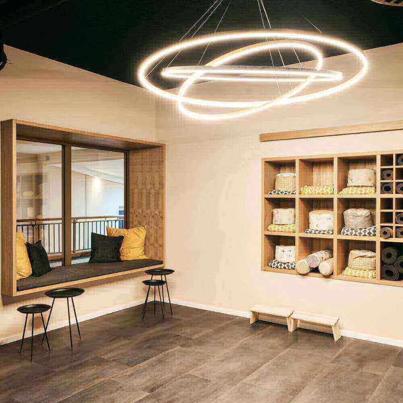 Modernes Interieur mit Leuchten, Holzregal und komfortablem Sitzbereich für ruhige Momente.