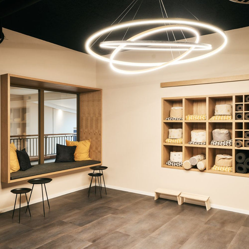 Modernes Interieur mit Leuchten, Holzregal und komfortablem Sitzbereich für ruhige Momente.