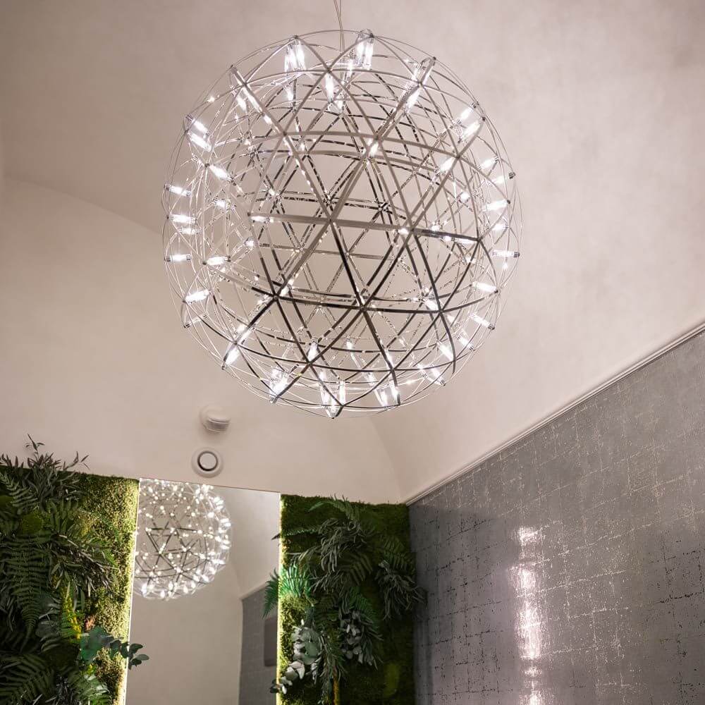 s.luce Atom LED-Hängeleuchte Dimmbar im modernen Raum mit Pflanzen und reflektierender Oberfläche.