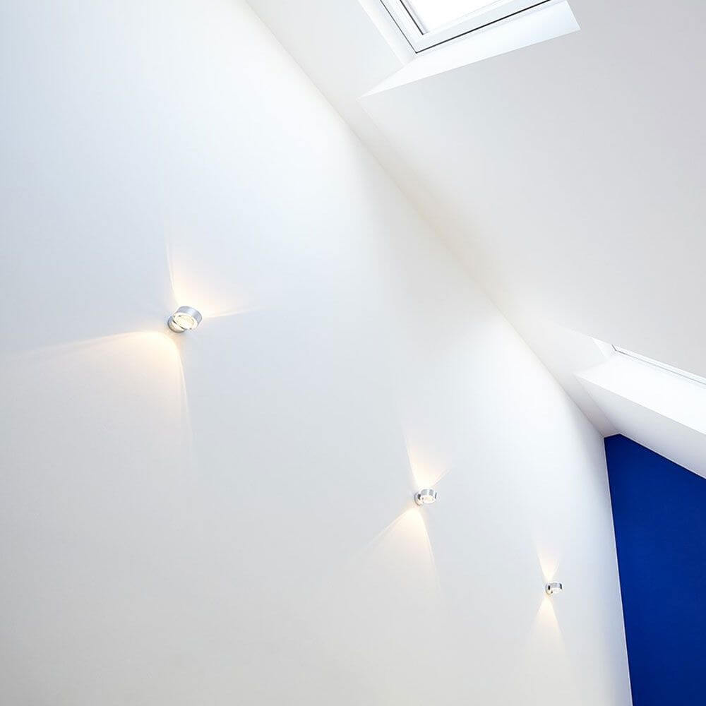 s.luce Beam LED-Wandleuchte modern Up & Down an einer weißen Wand mit Lichteffekten.