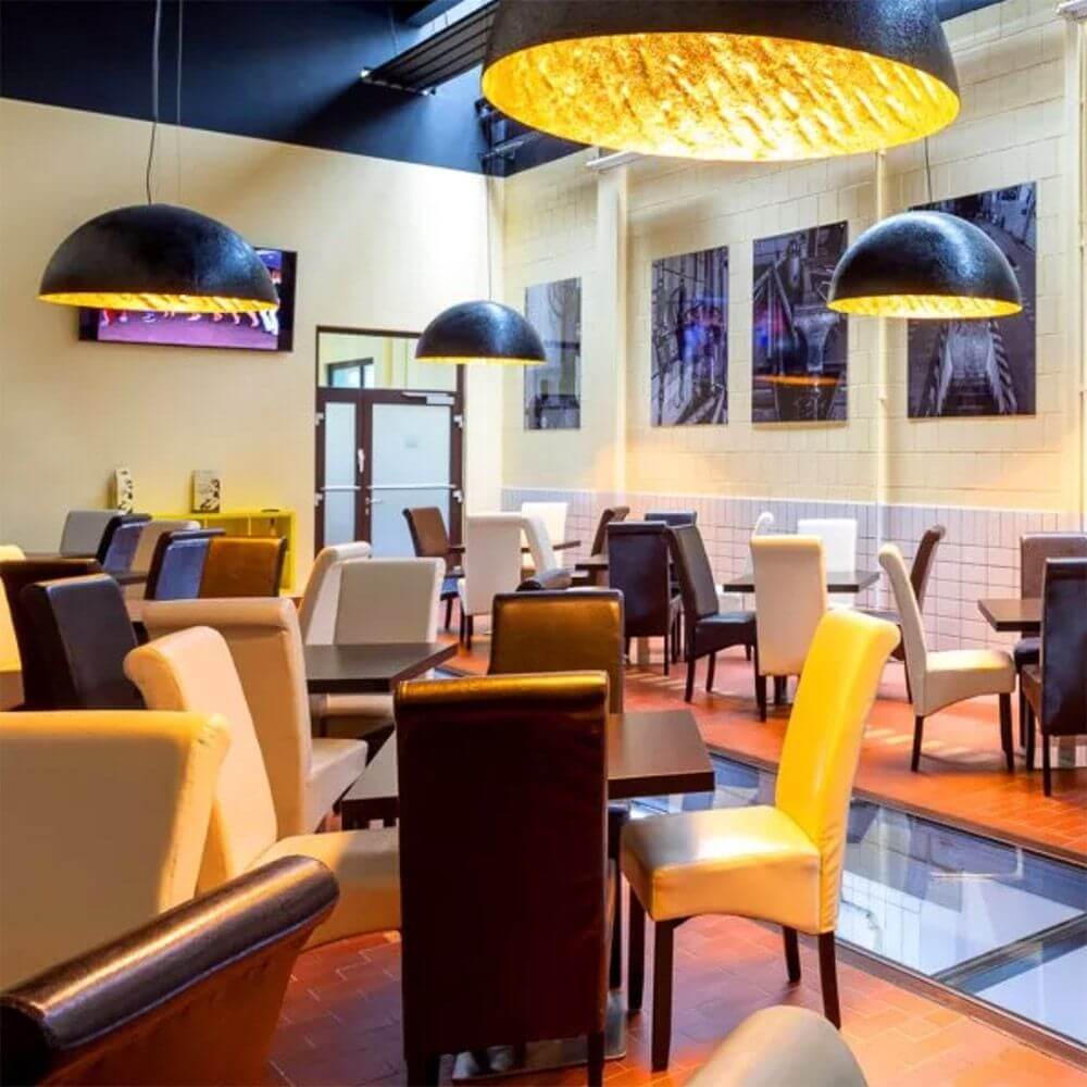 s.luce Blister Pendelleuchte Matt in einem modernen Restaurant mit stilvollem Interieur und verschiedenen Sitzgelegenheiten.