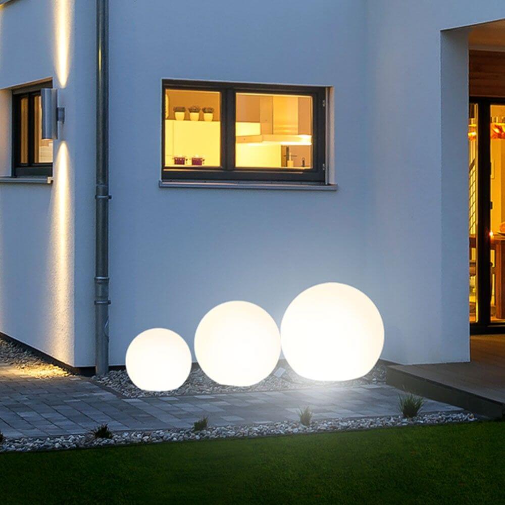 s.luce Globe Set Garten Kugelleuchten vor einem modernen Zuhause in stimmungsvollem Licht.