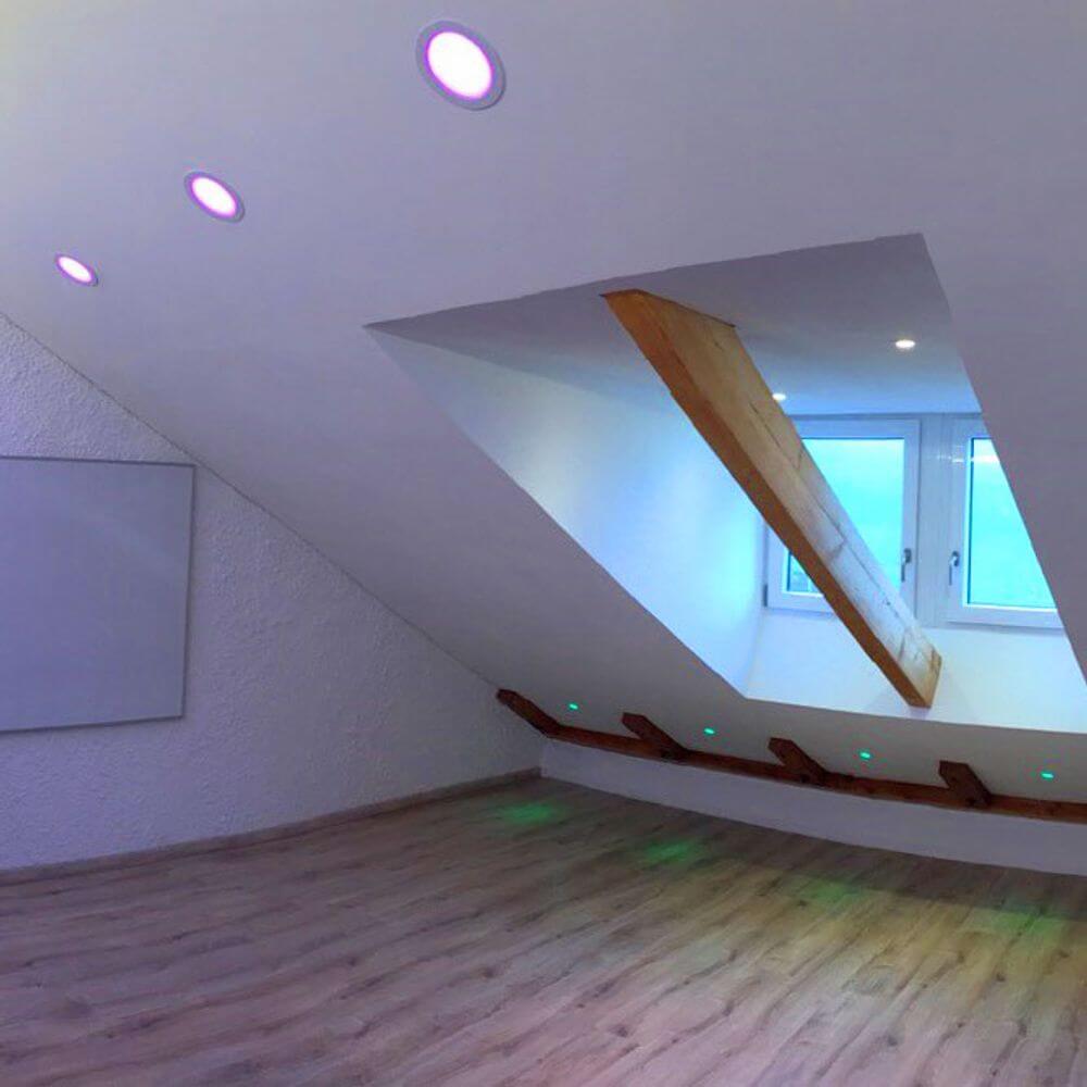 Modernes Wohnzimmer mit iLight LED-Einbaupanel in RGB-Farben und dimmbarer Helligkeit.