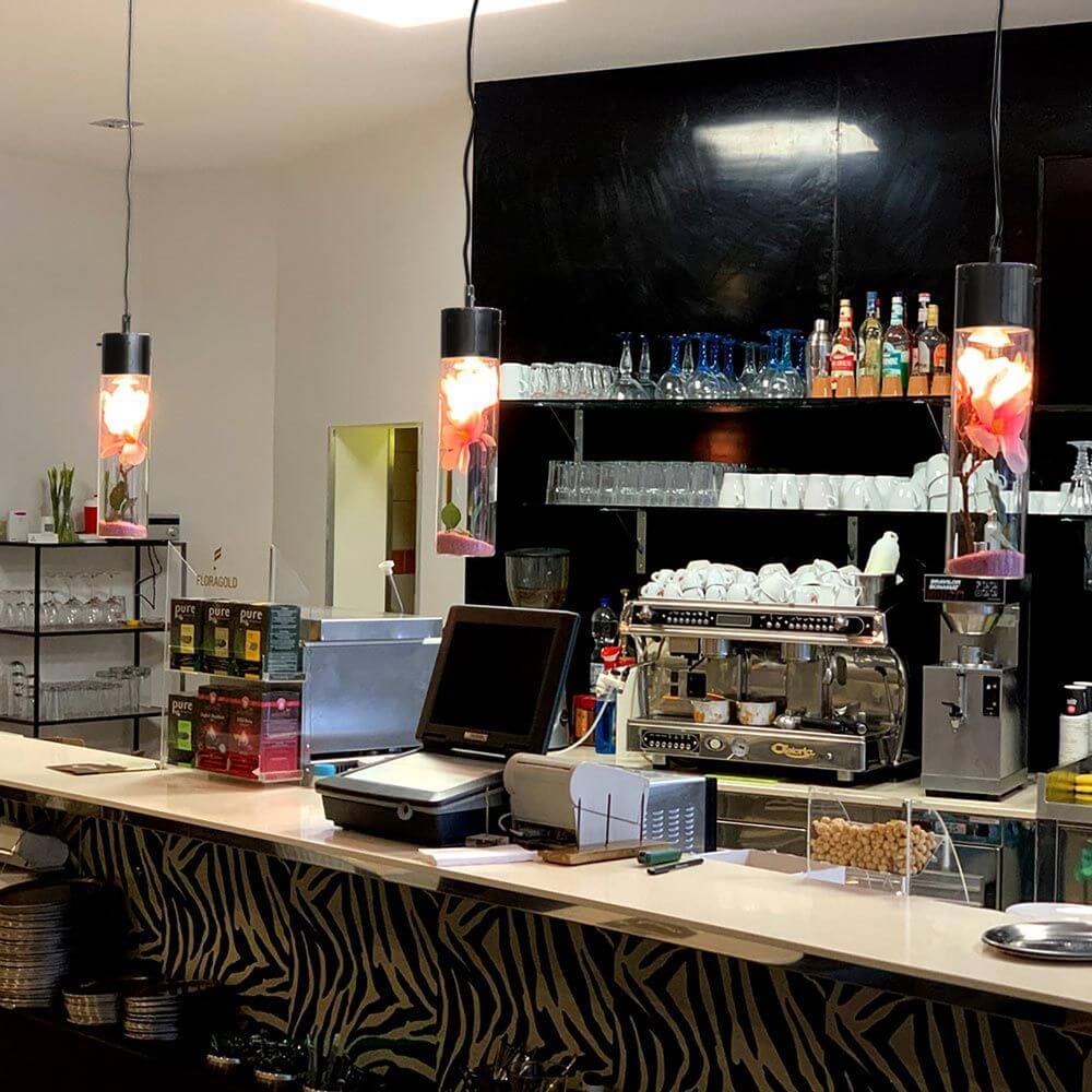 s.luce MyLight Hängeleuchte mit Schauzylinder im modernen Café-Ambiente über der Bar.