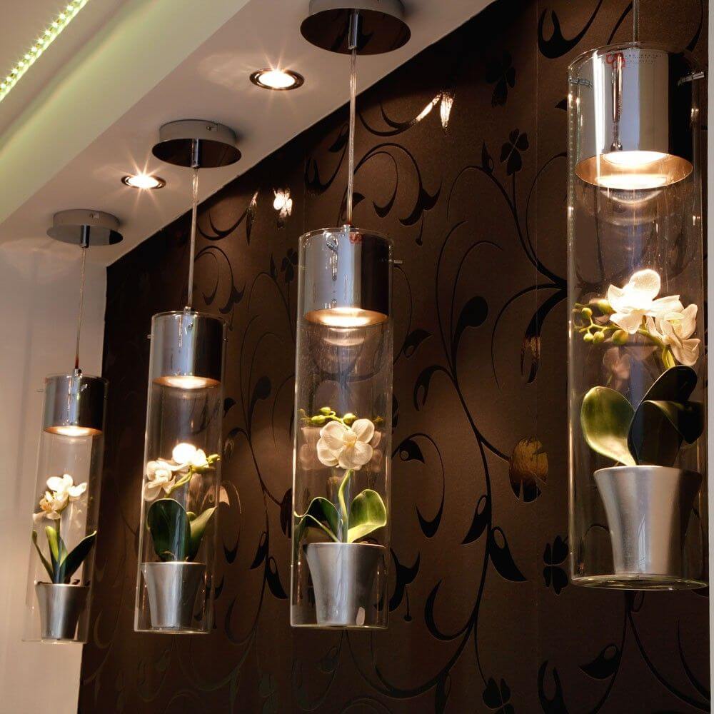 s.luce MyLight Hängeleuchte mit Schauzylinder, elegant dekoriert mit Orchideen in modernen Glanzübertöpfen.