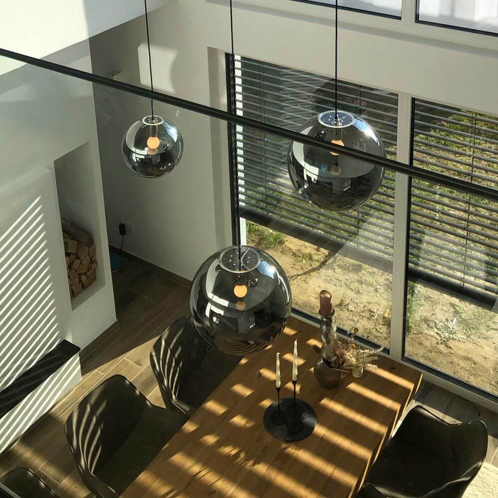 s.luce Orb XL Galerieleuchte 8-flammig mit Modular Baldachin über einem modernen Esstisch.