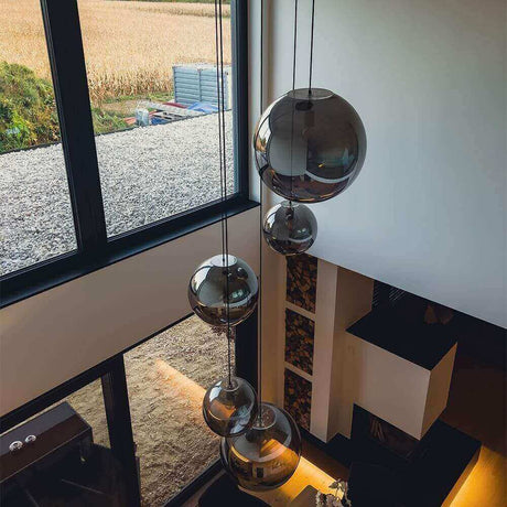 Moderne hängende Glaskugelleuchten über einem stilvollen Raum mit Blick auf die Natur.