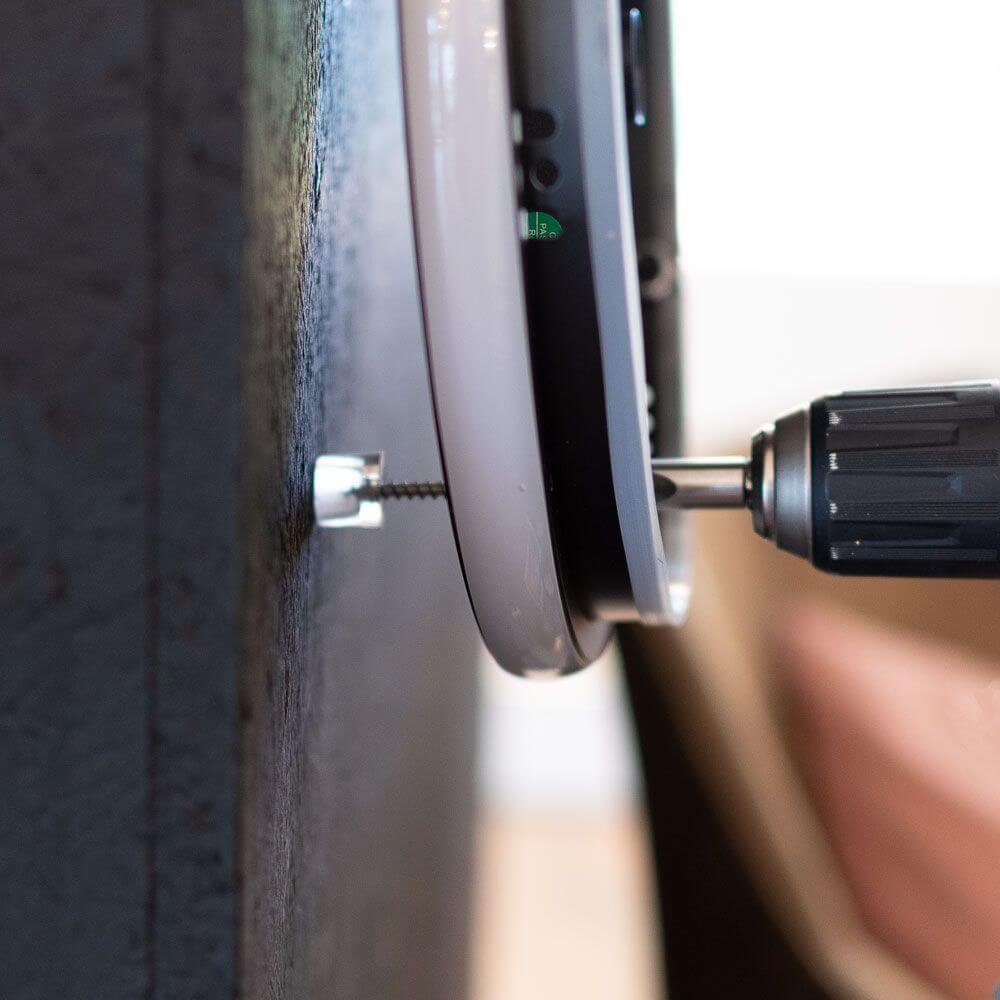 Installation eines Abstandhalters für s.luce Cloud Wandleuchte an der Wand mit einem Schraubenzieher.