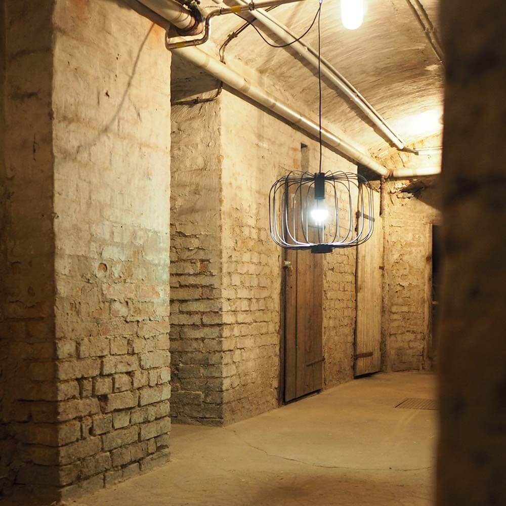 s.luce Rooms Hängeleuchte in einem rustikalen Raum mit Ziegelwänden und warmem Licht-Design.