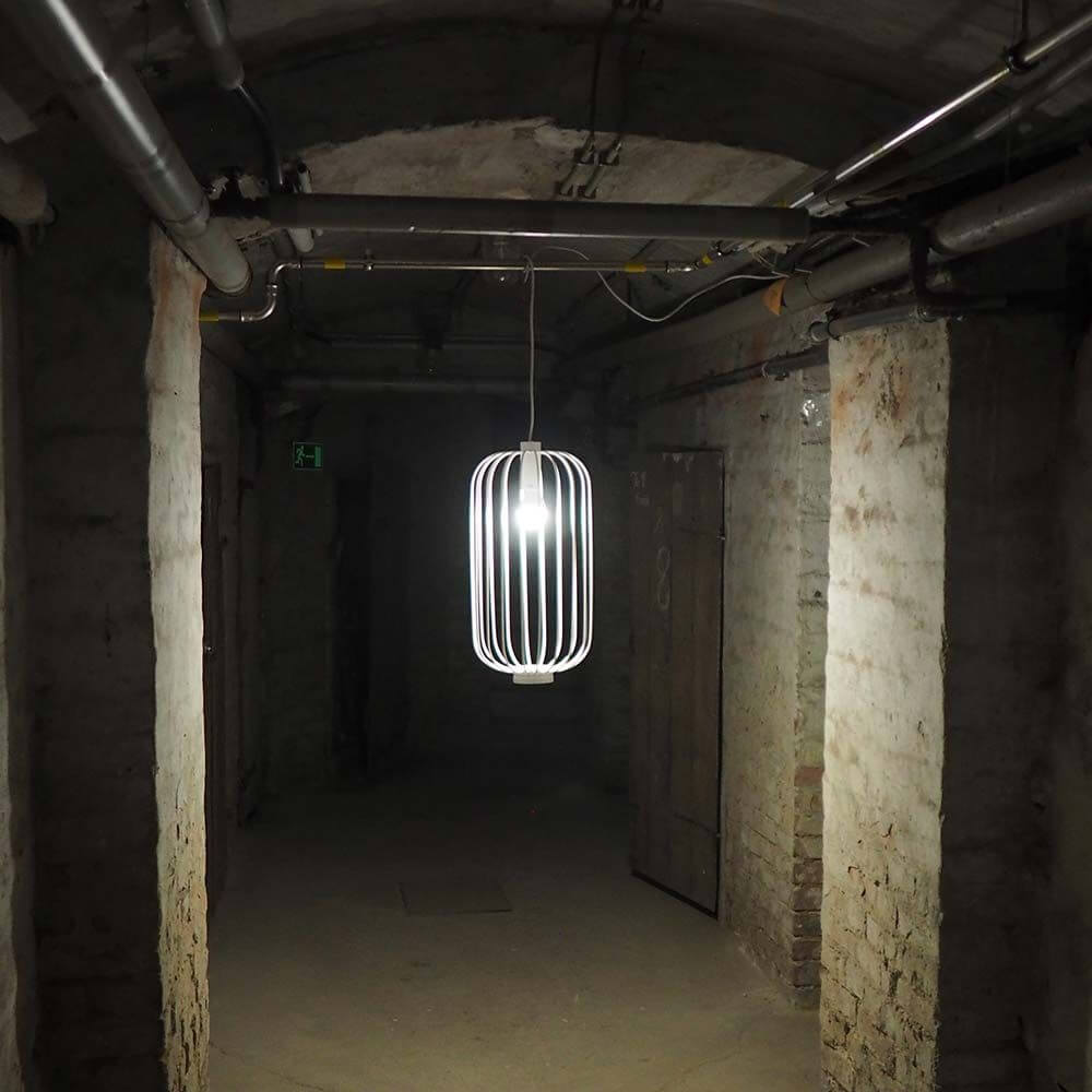 s.luce Rooms M direkt & indirekte Gitter-Pendelleuchte Ø30cm in einem stilvollen, industriellen Raum mit sanfter Beleuchtung.