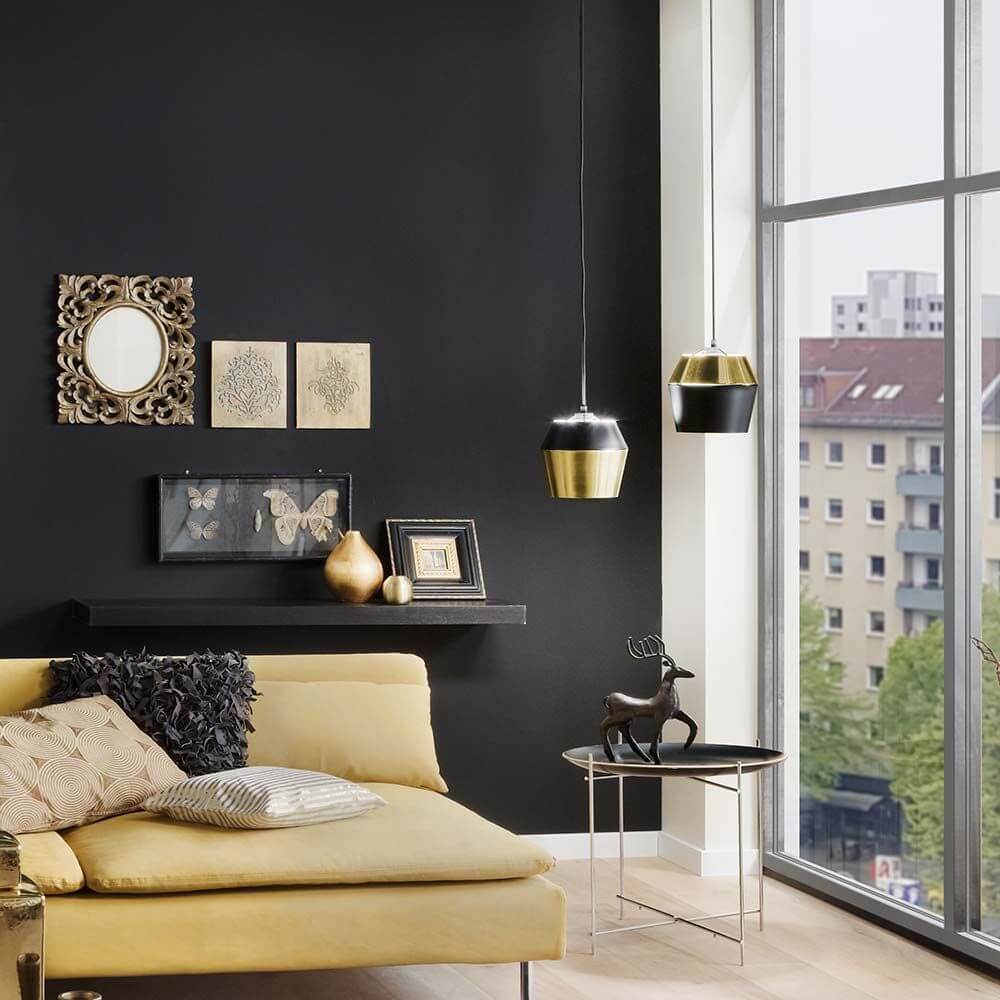 s.luce SkaDa LED Pendellampe Metallschirm in modernem Wohnkonzept mit gelbem Sofa und großen Fenstern.