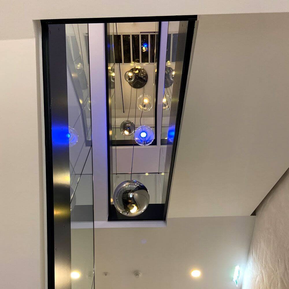 Moderne s.luce Sphere Galerieleuchte in einem Treppenhaus mit asymmetrischer Lichtverteilung.