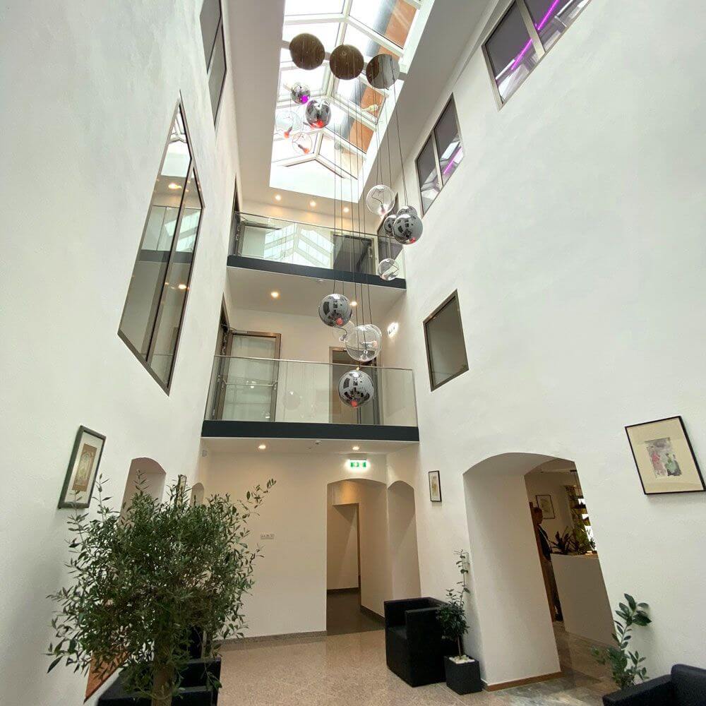 Moderne Galerie mit s.luce Sphere Hängeleuchte in einem hellen Innenbereich, ideal für Treppenhäuser und Wohnräume.