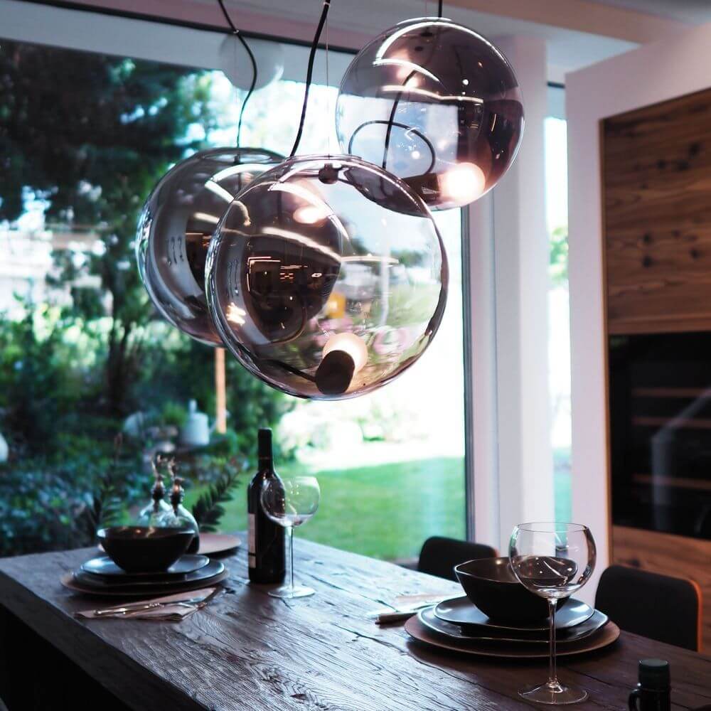 s.luce Sphere Galerieleuchte 3- oder 5-flammig Modular Baldachin über einem gedeckten Esstisch in modernem Ambiente.