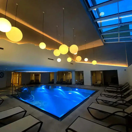 Entspannender Wellnessbereich mit Pool und stimmungsvollen Leuchten bei Nacht.