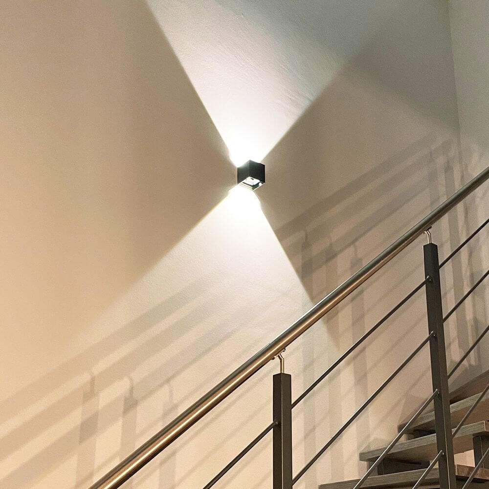 s.luce Ixa LED High Power Wandlampe IP20 an einer Wand, modernes Design und stimmungsvolle Beleuchtung.