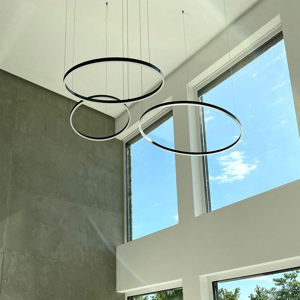 s.luce LED Ring Pendellampe in modernem Raum mit großen Fenstern, schlichte Eleganz und minimalistischem Design.