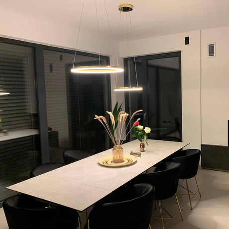 s.luce Lâmpada pendente em anel LED Ø 40cm sobre uma elegante mesa de jantar em um ambiente moderno.