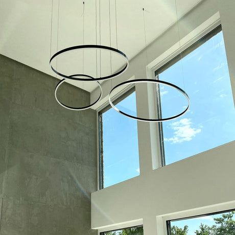 s.luce LED Ring Hängeleuchte in modernem Design, Ø 60cm, über großen Fenstern in hellem Raum.