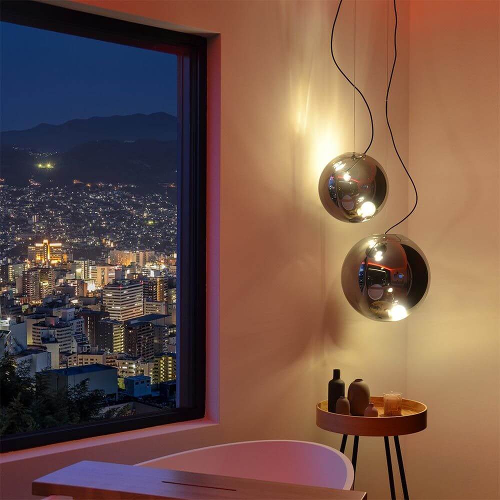 Moderne s.luce Sphere Pendelleuchte Glaskugel mit asymmetrischer Lichtverteilung bei Nacht.