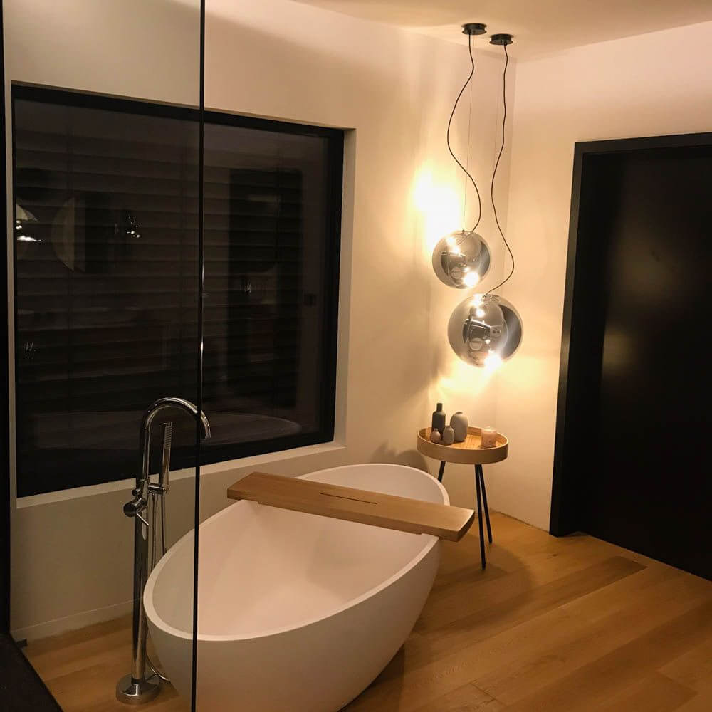 s.luce Sphere Galerieleuchte Glaskugel 5m Abhängung, moderne Hängelampe im Badezimmer über freistehender Badewanne.