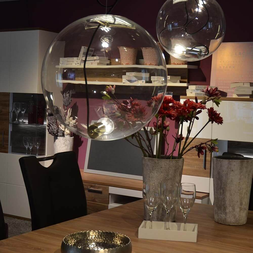 Moderne s.luce Sphere Pendelleuchte aus Glas in einem stilvollen Esszimmer mit Blumen und dekorativen Elementen.