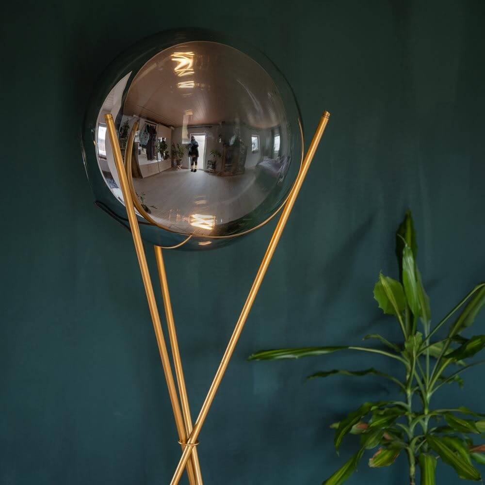 s.luce Stehleuchte Progress 40cm mit eleganter Glaskugel und goldenen Dreibeinen auf einem stilvollen Hintergrund.