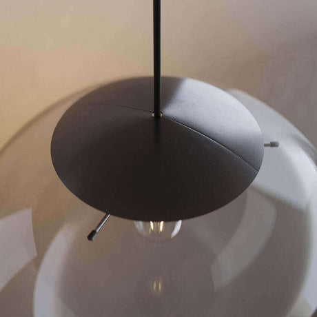 Elegante hängende Lampe mit schwarzem Schirm und glasklarem Lampenkörper in stilvollem Design.