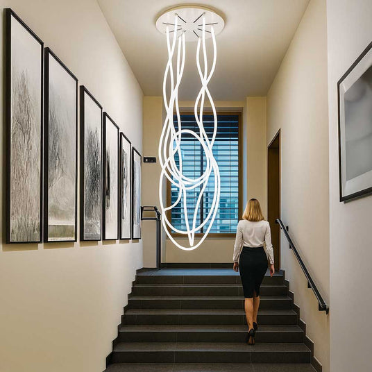 s.luce Arion organische Flex LED Hängelampe Warmweiß hängt in einem modernen Treppenhaus und erzeugt beeindruckende Lichtskulpturen.