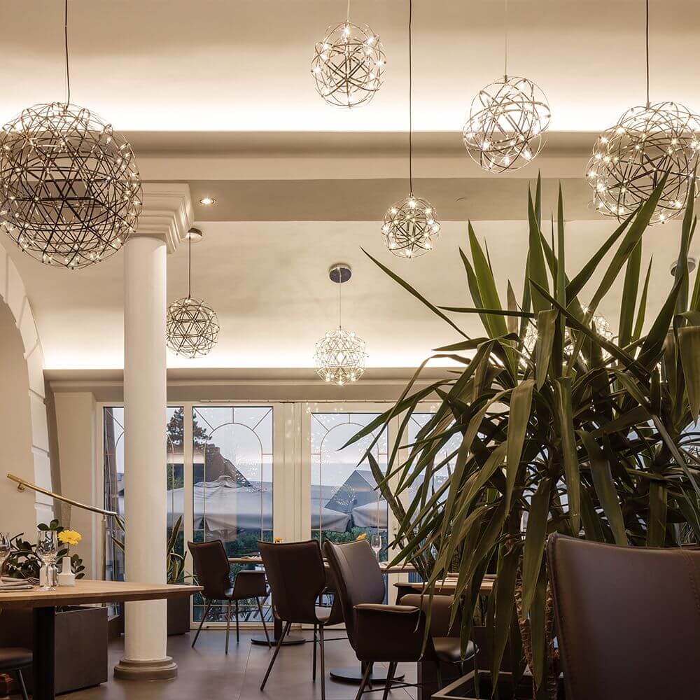 s.luce Atom LED-Hängeleuchte Dimmbar in modernem Restaurant mit Pflanzen und stylischer Beleuchtung