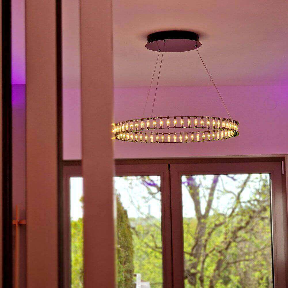 Moderne Deckenleuchte mit schimmernden Lichtern, die an einem Kabel hängen, in einem Raum mit Fenstern.