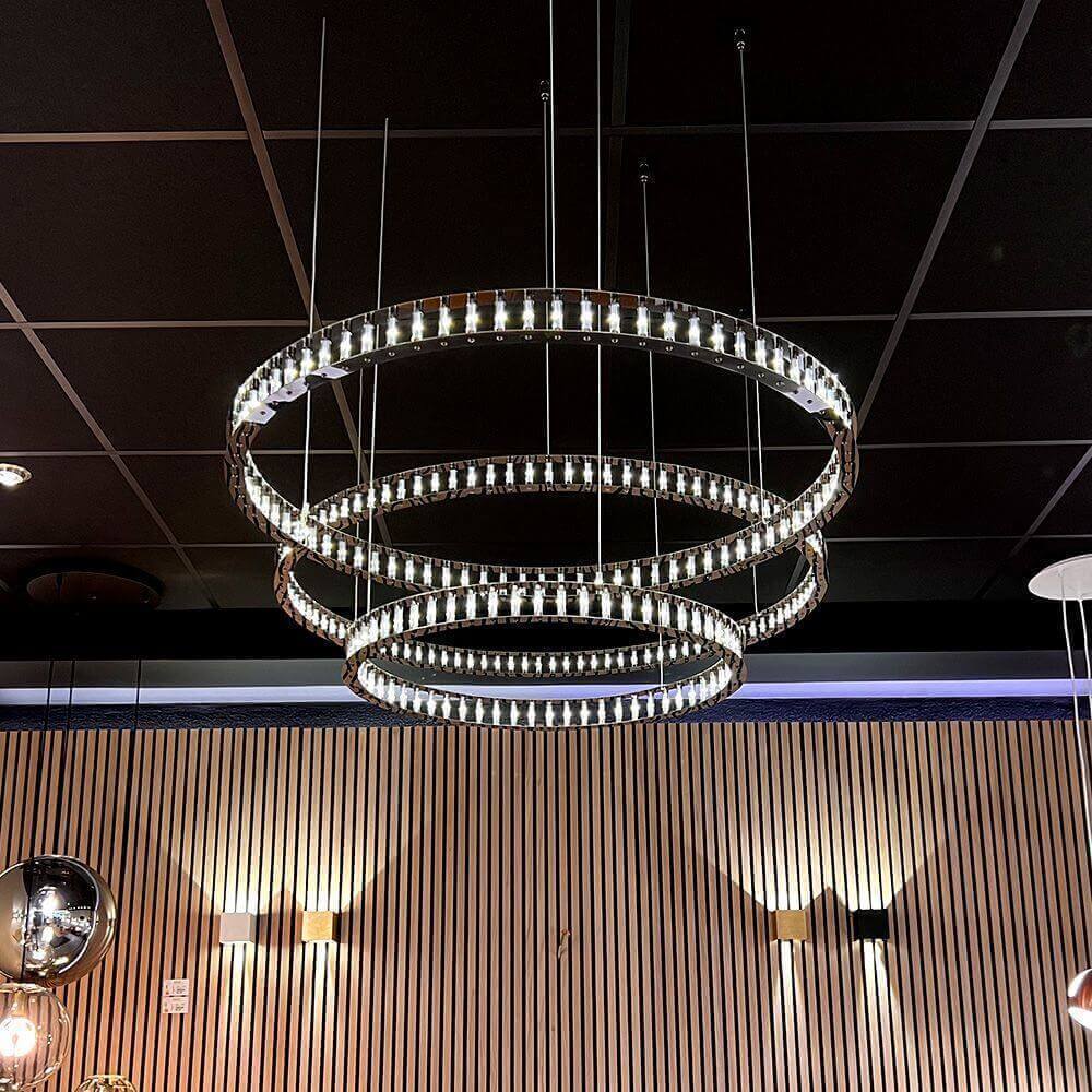 s.luce Lámpara colgante LED Atom Ring regulable en un interior moderno con anillos metálicos luminosos flotantes.