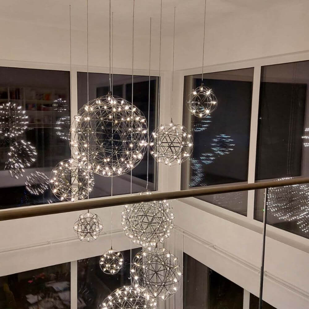 Schicke hängende Lampen in geometrischen Formen mit warmem Licht, die einen modernen Raum beleuchten.