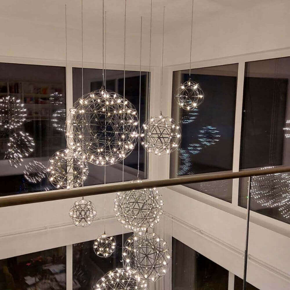 Schicke hängende Lampen in geometrischen Formen mit warmem Licht, die einen modernen Raum beleuchten.