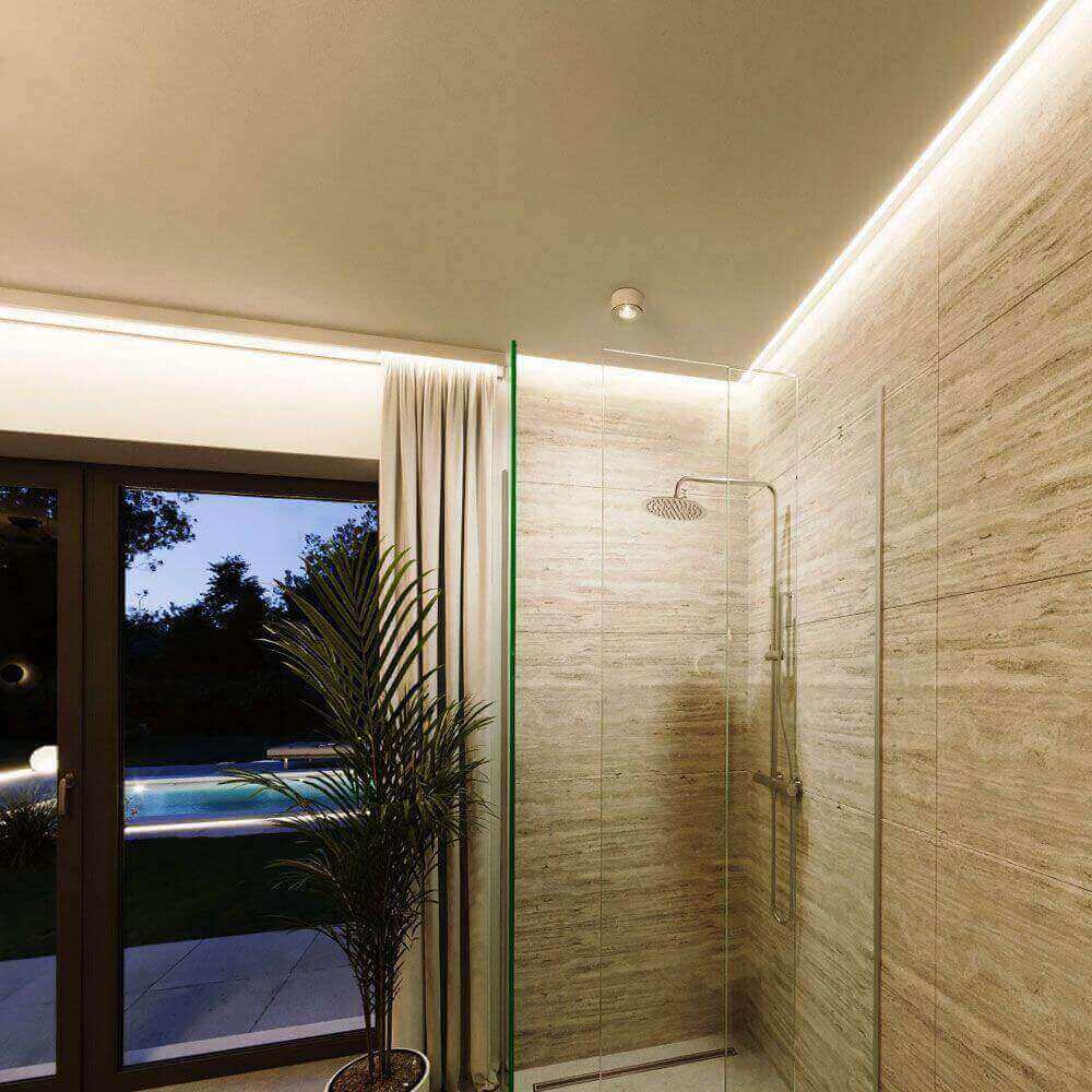 Moderne Dusche mit Glaswänden, sanfter Beleuchtung und Blick auf den Garten mit Pool.