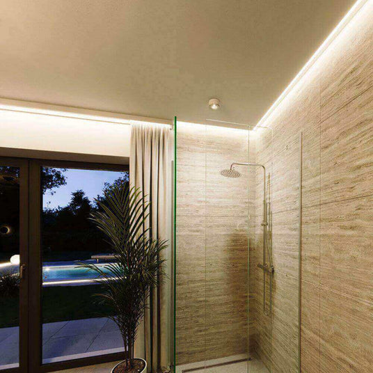 Moderne Dusche mit Glaswänden, sanfter Beleuchtung und Blick auf den Garten mit Pool.