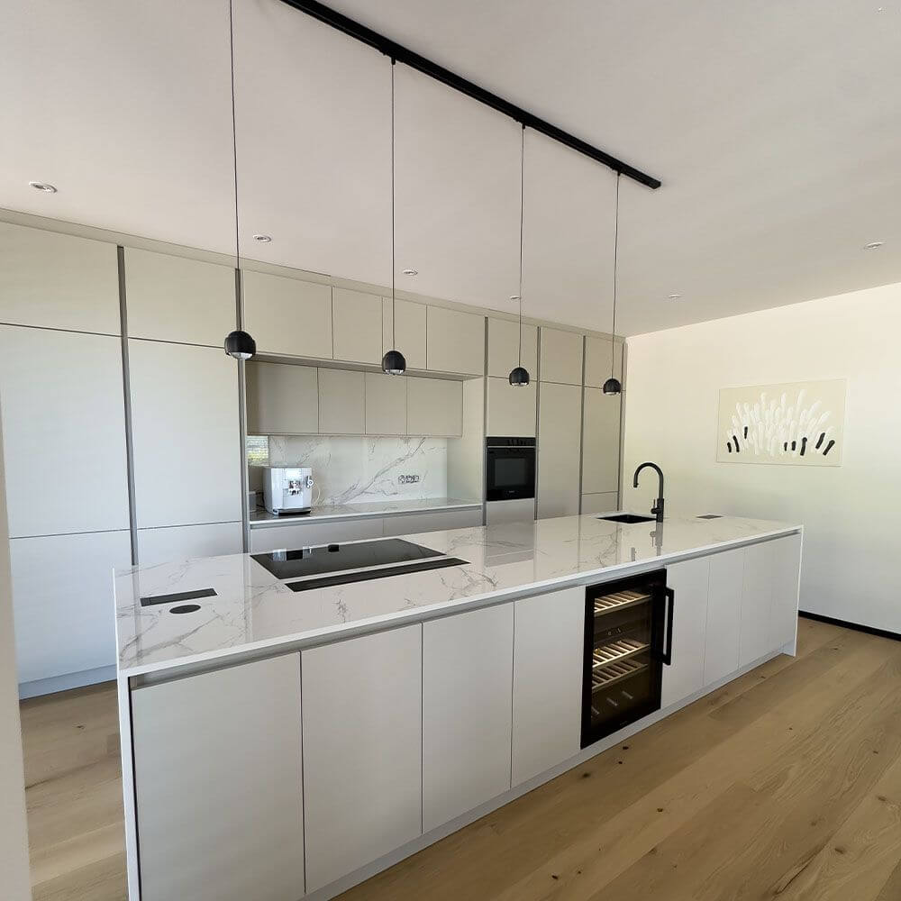 s.luce Beam LED Hängelampe 1-Phasen-Schienensystem Mitteleinspeiser über einem eleganten Küchentresen.