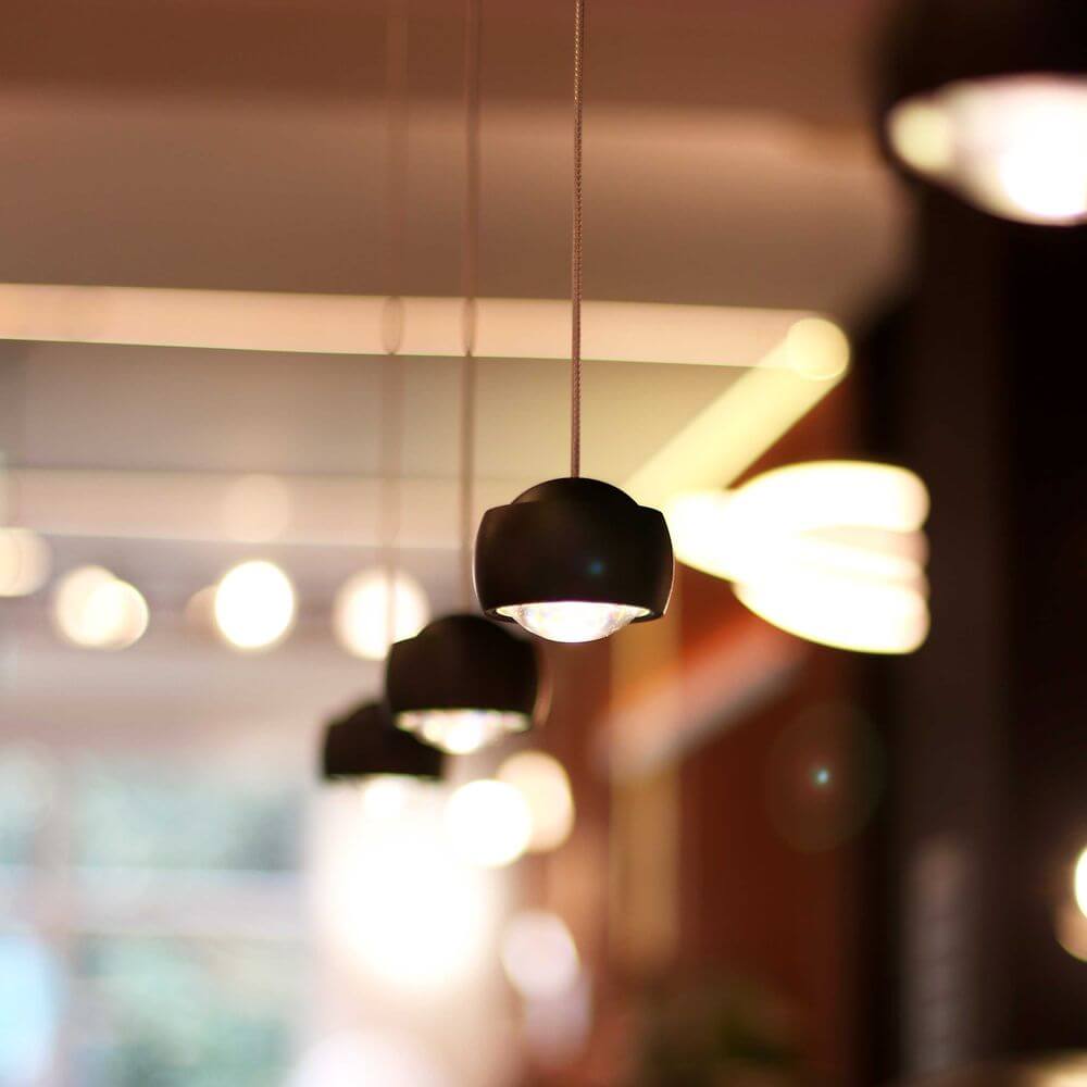 s.luce Beam LED Hängeleuchte 1-Phasen-Schienensystem Endeinspeiser in modernem Design über Tisch.