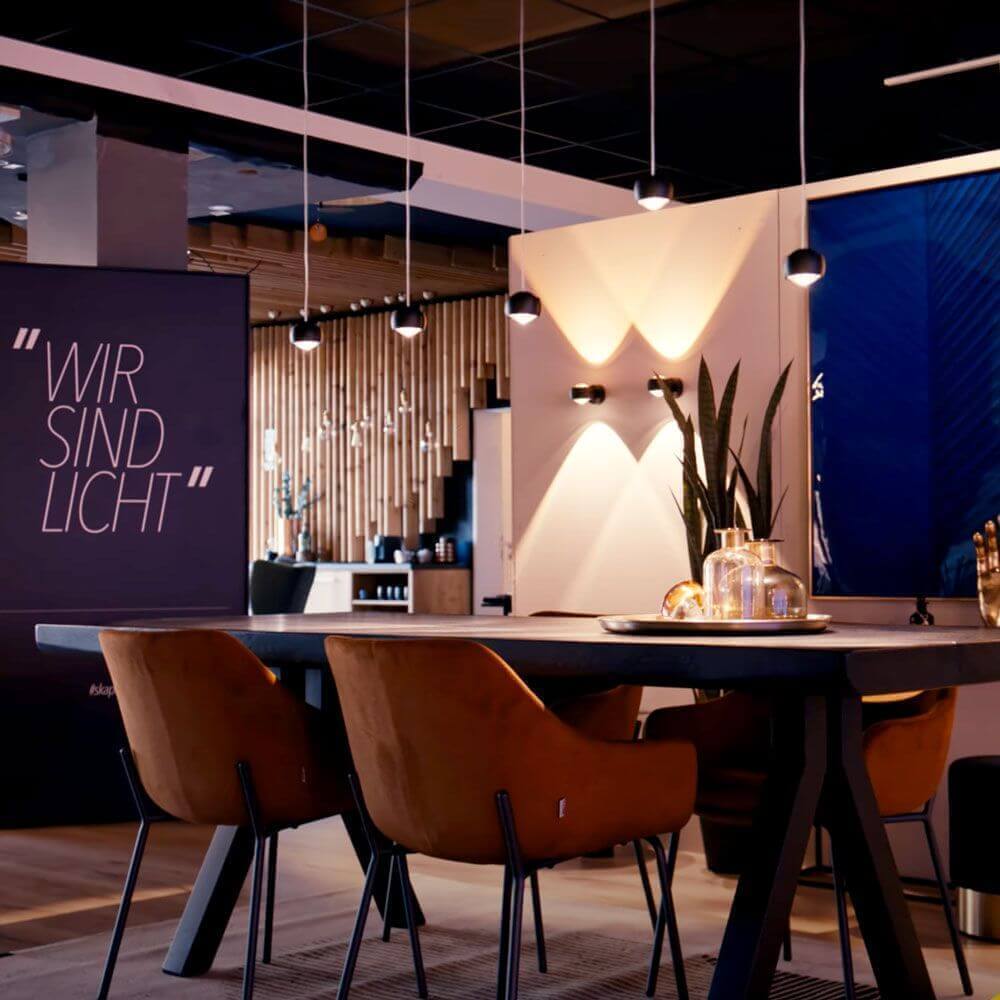 Modern furnishings with table, chairs, and wall decor; slogan "WE ARE LIGHT" in the background.