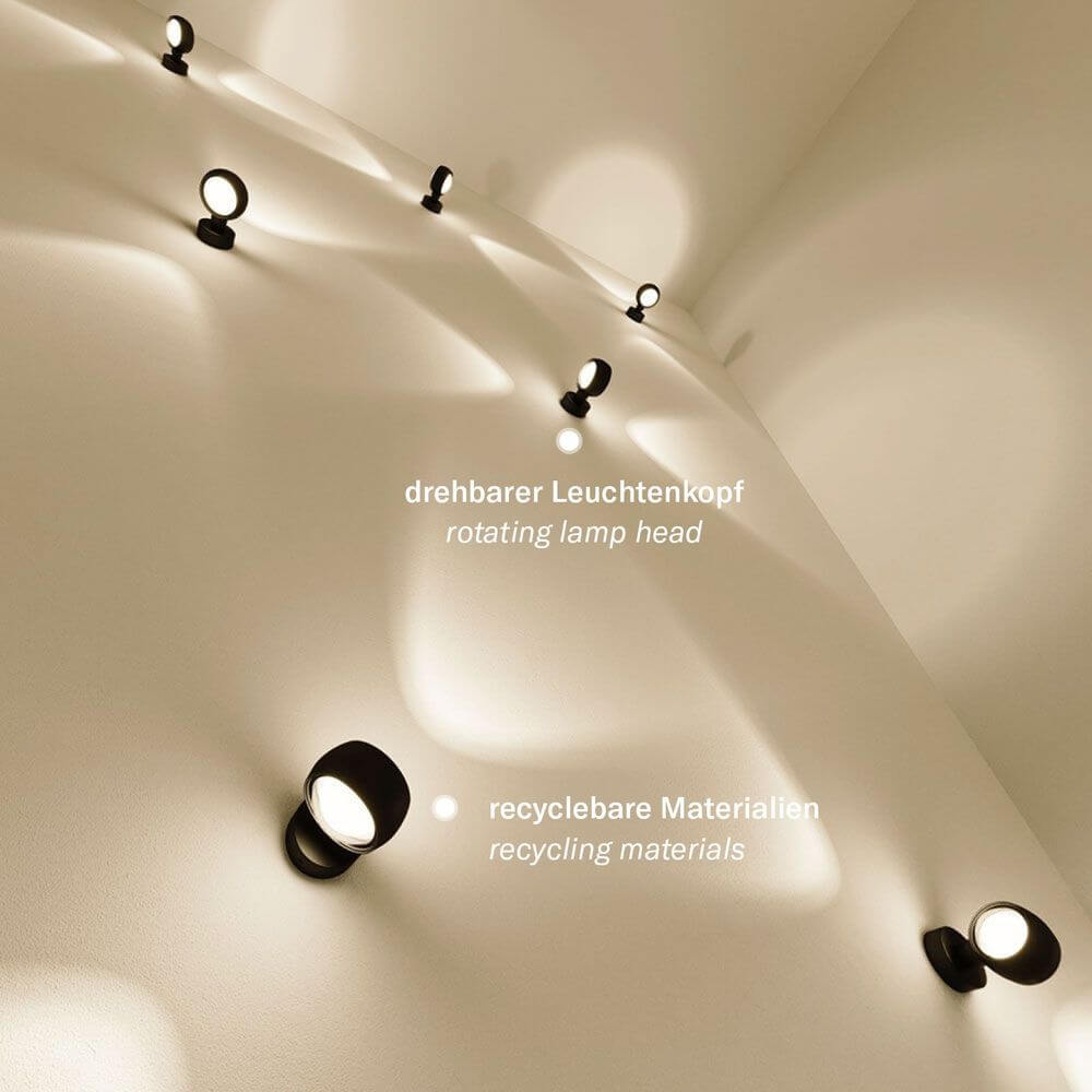 s.luce Applique murale Beam Up & Down avec lentilles en verre sur un mur, tête de lampe pivotante et matériaux recyclables.