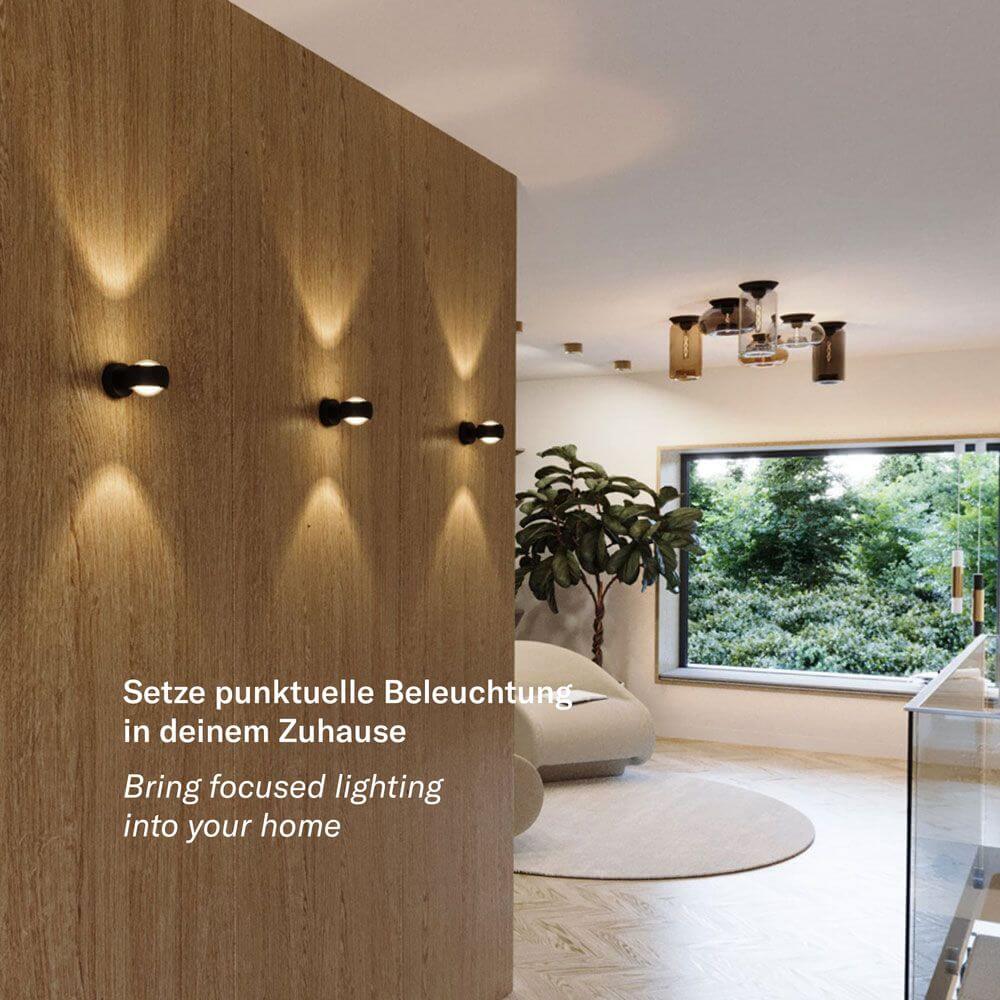 s.luce Beam Wandleuchte Up & Down mit Glaslinsen in modernem Wohnbereich mit Holzpaneelen
